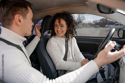 Φωτογραφία Man talking something to curly woman in car