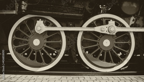 Fotografie Steel wheels of a vintage steam locomotive in sepia style