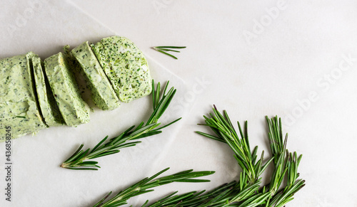 Homemade butter with herbs and rosemary for sandwiches and steak sliced on marble background.  photo