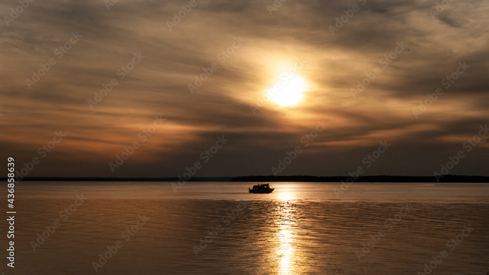 A boat travels across the horizon on a large lake in Oklahoma