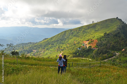 Two girls in the green meadow on mountaintop
