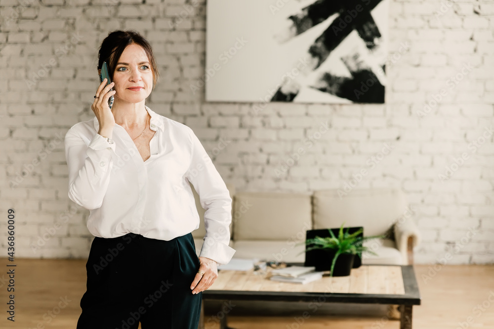 Middle aged business woman talking on the phone and and smiling Middle aged business woman talking on the phone and and smiling