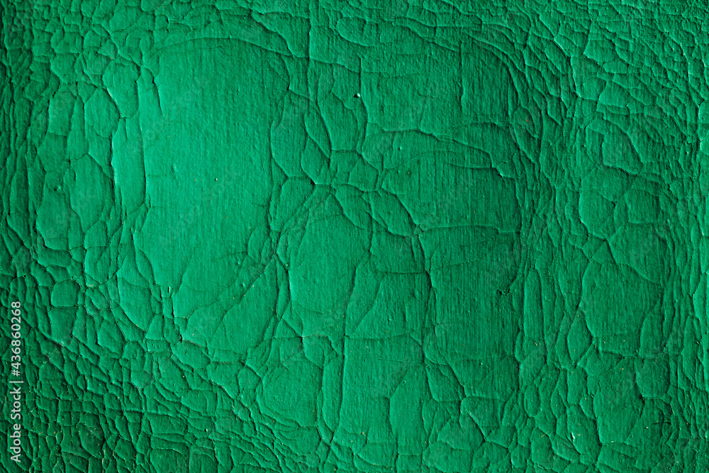 Background wooden board with cracked paint. Color-Peel wood texture. Green wall with peeled paint. Close up. Space for text.