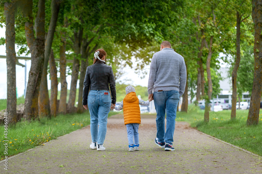 Happy family walking in the summer park and holding hands. Happy family walking in the summer park and holding hands.