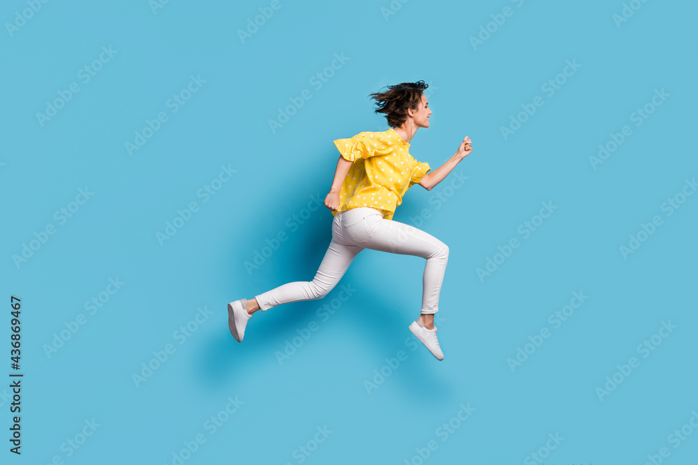 Full size profile side photo of dreamy charming girl jump up air runner empty space isolated on pastel blue color background Full size profile side photo of dreamy charming girl jump up air runner empty space isolated on pastel blue color background