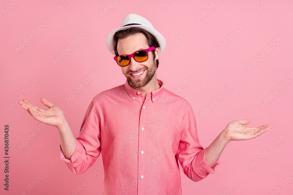 Portrait of attractive cheerful guy wearing specs welcoming on trip isolated over pink pastel color background