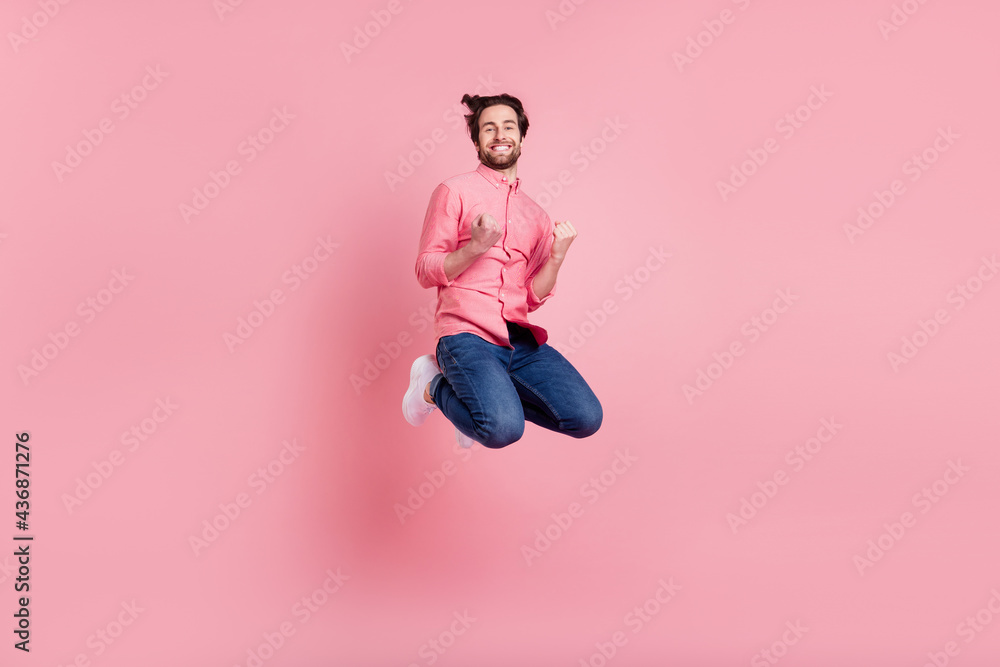 Full body photo of funky happy charming man jump up air winner celebrate isolated on pink color background Full body photo of funky happy charming man jump up air winner celebrate isolated on pink color background