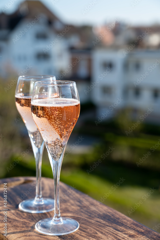 Drinking of rose champagne sparkling wine from flute glasses on outdoor terrace in France Drinking of rose champagne sparkling wine from flute glasses on outdoor terrace in France