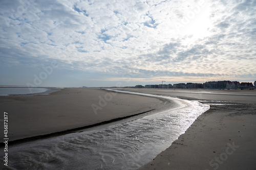 Low tide period on yellow sandy beach in small Belgian town De Haan or Le Coq sur mer, luxury vacation destination, summer holidays photo