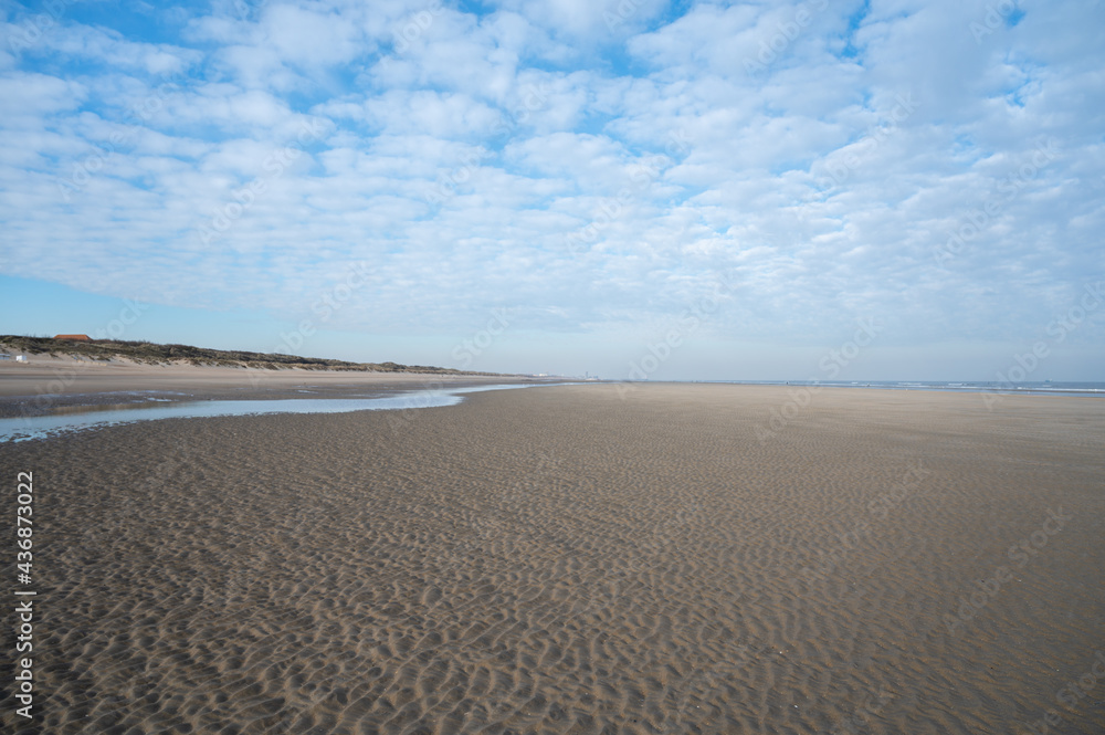 Low tide period on yellow sandy beach in small Belgian town De Haan or Le Coq sur mer, luxury vacation destination, summer holidays Low tide period on yellow sandy beach in small Belgian town De Haan or Le Coq sur mer, luxury vacation destination, summer holidays