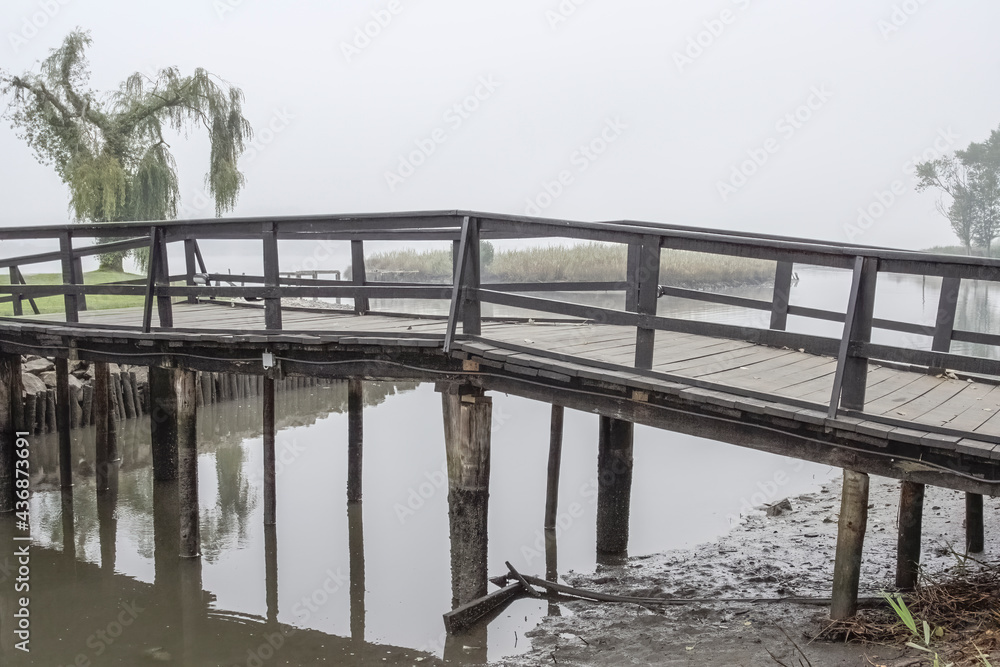 Wooden bridge in a misty morning.