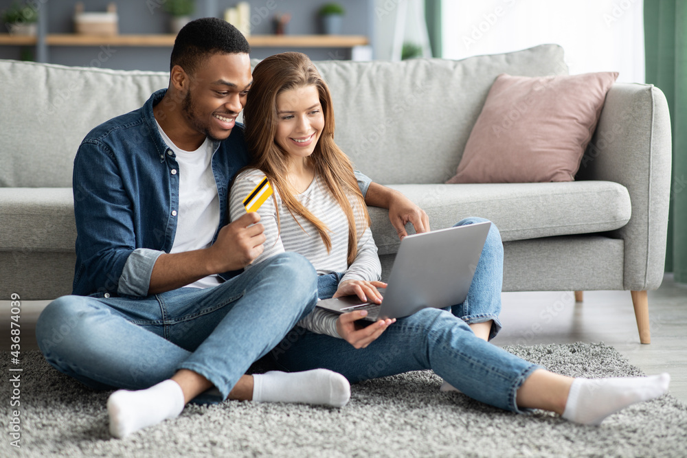 Online Shopping. Cheerful Mixed Couple Using Laptop And Credit Card At Home Online Shopping. Cheerful Mixed Couple Using Laptop And Credit Card At Home