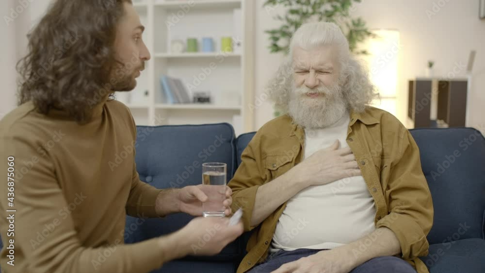 Aged man suffering from chest pain but rejecting meds and water from caring son Aged man suffering from chest pain but rejecting meds and water from caring son