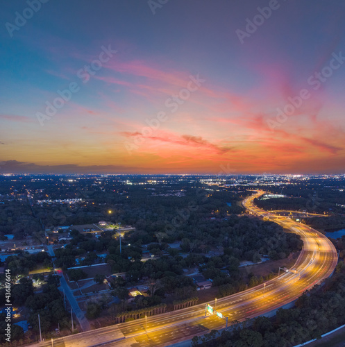 Beautiful long exposure sunset taken at dusk in Tampa, Florida with amazing clouds, car light trails on the highway, and pastel colors.