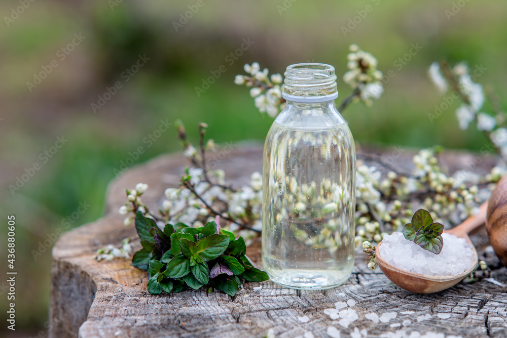 Spa and wellness setting with sea salt, oil essence, flowers and Spa and wellness setting with sea salt, oil essence, flowers and