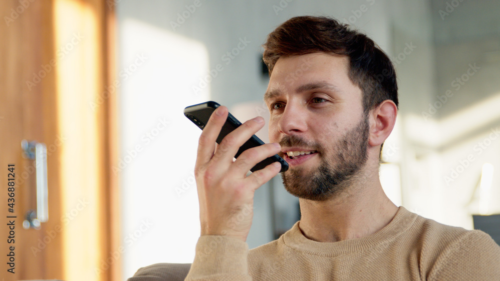 Smiling male recording an audio message Smiling male recording an audio message