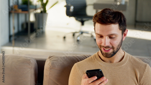 Handsome man using phone at home