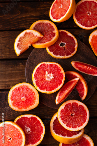 sliced pieces of grapefruit lie on the table on the dark wooden countertop