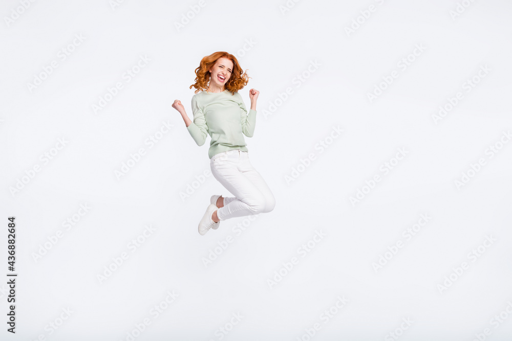 Full length body size photo young woman red hair jumping up gesturing like winner isolated white color background