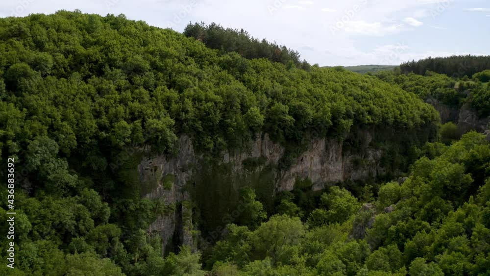 Drone flight over a picturesque river canyon, high sheer cliffs overgrown with greenery Drone flight over a picturesque river canyon, high sheer cliffs overgrown with greenery