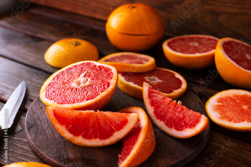 sliced pieces of grapefruit lie on the table on the dark wooden countertop