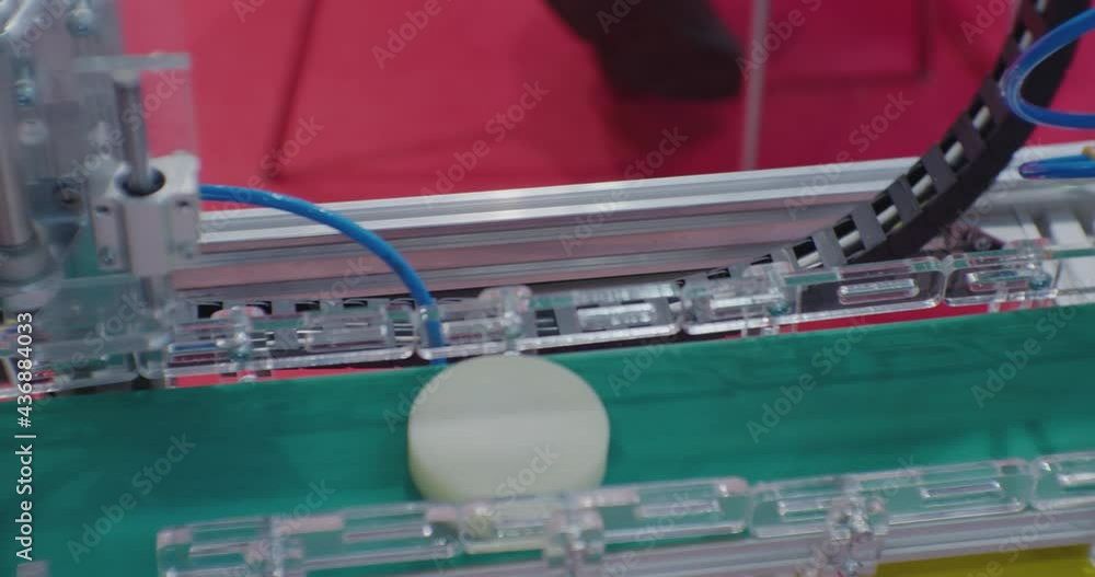 modern production.the round part is moved by the manipulator and moves along the conveyor belt.close-up.view from above. modern production.the round part is moved by the manipulator and moves along the conveyor belt.close-up.view from above.