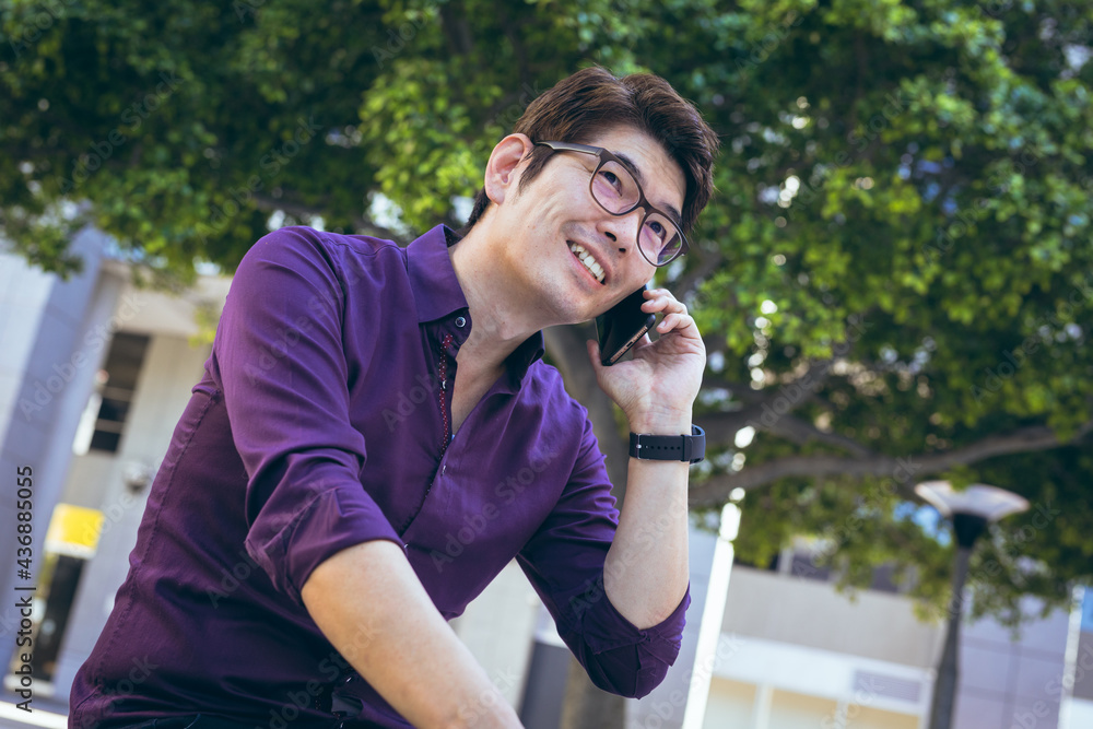 Smiling asian businessman using smartphone in city street Smiling asian businessman using smartphone in city street