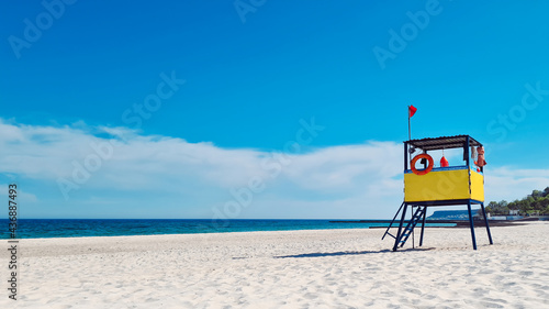 Lifeguard tower on the beach against the background of the sea and blue sky (ID: 436887493)