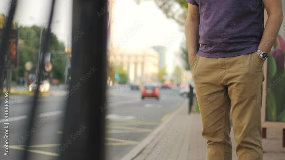 Portrait of a man in a medical mask waiting for a bus at a bus stop. Portrait of a man in a medical mask waiting for a bus at a bus stop.