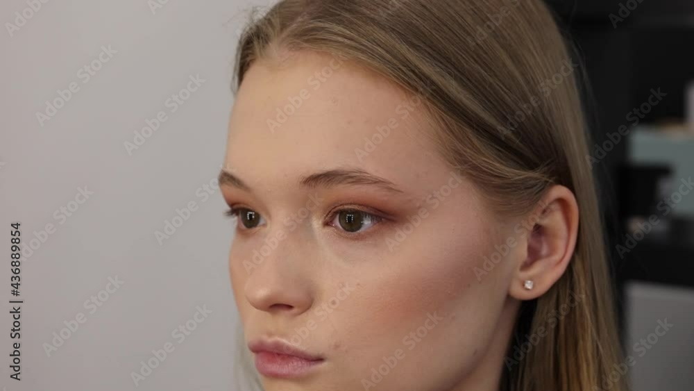 process of face makeup brush alignment of the face tone on a beautiful young woman model blonde process of face makeup brush alignment of the face tone on a beautiful young woman model blonde