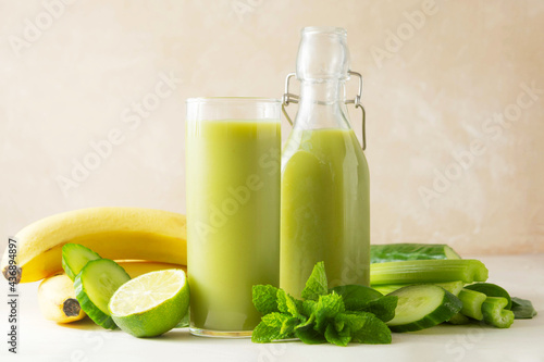 Green smoothie detox drink with apples, spinach, cucumber, lime, bananas.