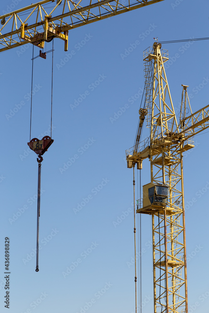 Hydraulic luffing jib tower cranes and workers being poured concrete into foundation. Cement pouring into formwork of building at construction site. Tower cranes constructing a new residential build Hydraulic luffing jib tower cranes and workers being poured concrete into foundation. Cement pouring into formwork of building at construction site. Tower cranes constructing a new residential build