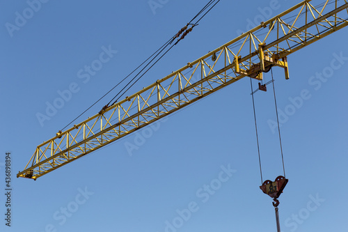 Vászonkép Hydraulic luffing jib tower cranes and workers being poured concrete into foundation