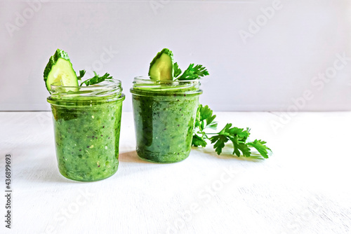 Green cocktail of spinach, lemon, cucumber and parsley on a light background. The concept of healthy nutrition, detox, green, diet, vegan, keto.