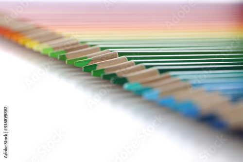 Colored pencils lie in row in background
