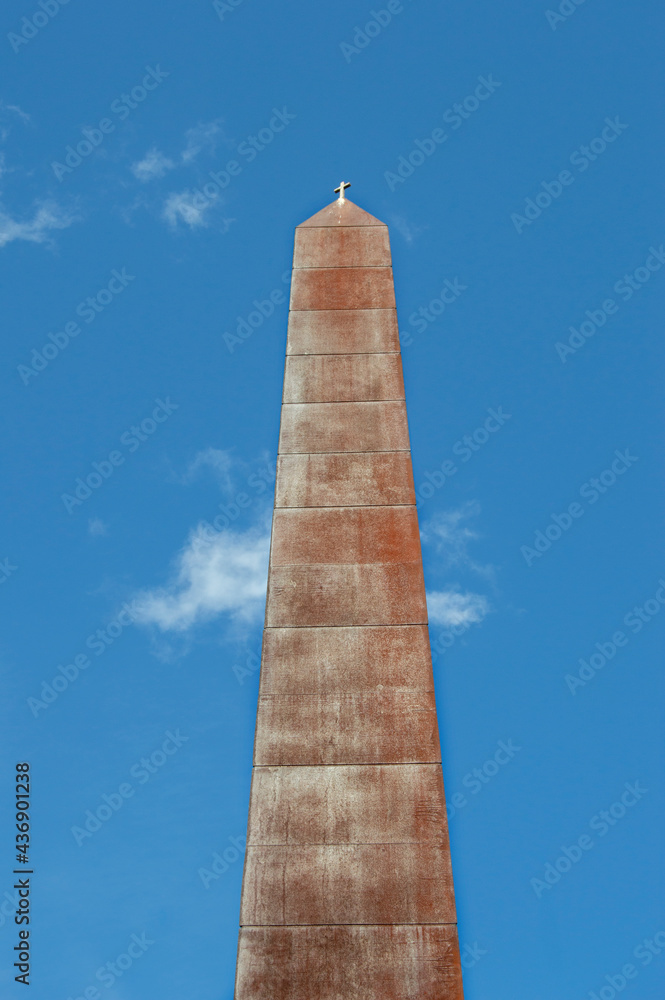 Obraz premium Iron obelisk with a small cross on a street in Madrid. Spain