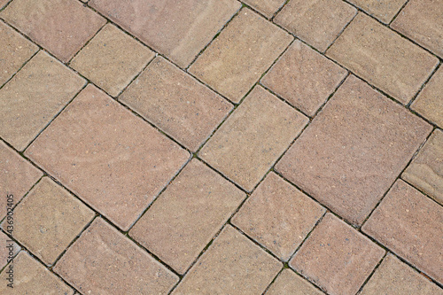 Stone block pavement. Brown paving slabs, close up. Pattern of paving blocks, top view