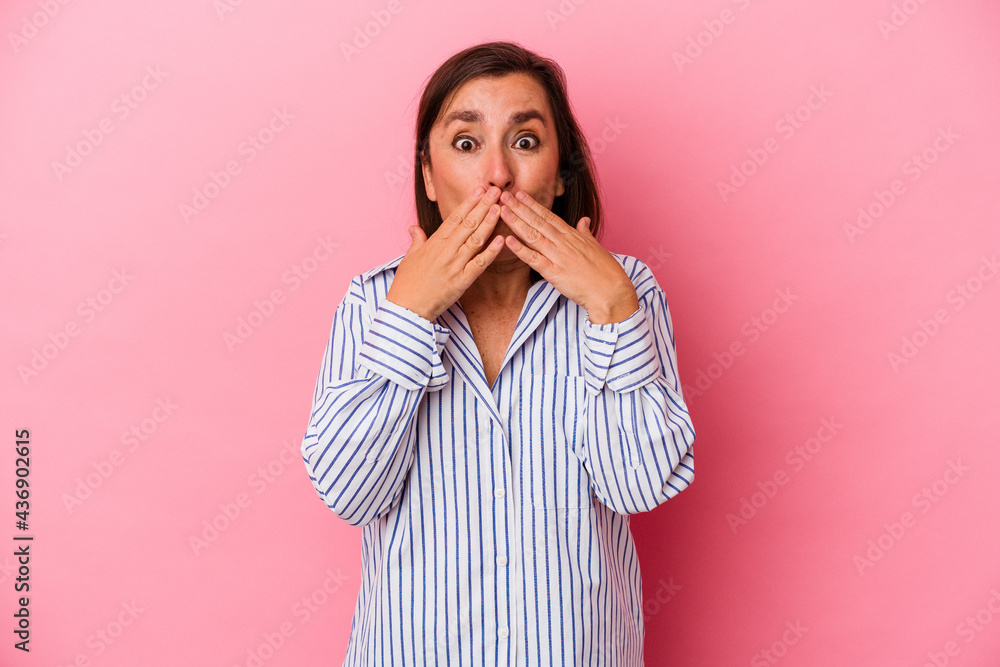 Middle age caucasian woman isolated on pink background shocked covering mouth with hands. Middle age caucasian woman isolated on pink background shocked covering mouth with hands.