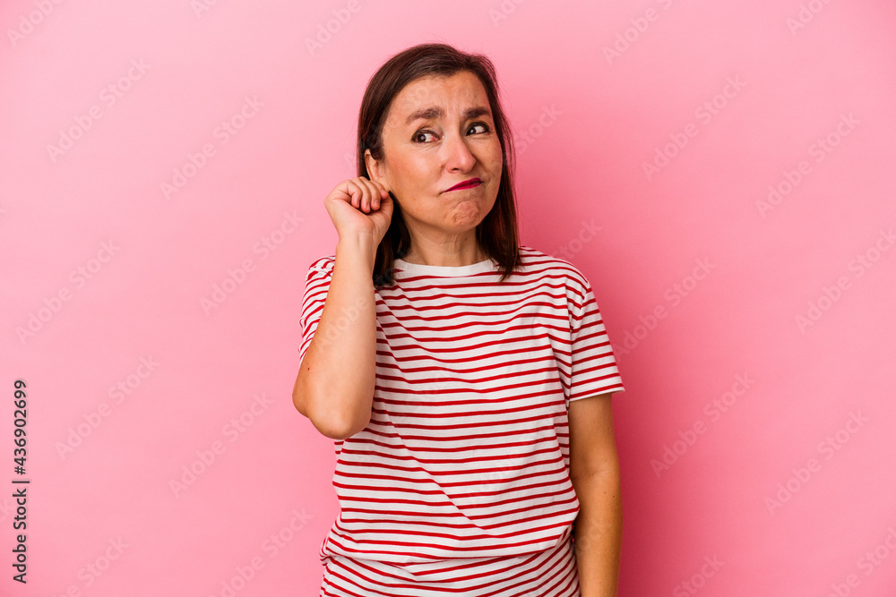Middle age caucasian woman isolated on pink background covering ears with fingers, stressed and desperate by a loudly ambient. Middle age caucasian woman isolated on pink background covering ears with fingers, stressed and desperate by a loudly ambient.
