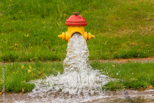 An suburban fire hydrant that has been opened letting water freely flow.