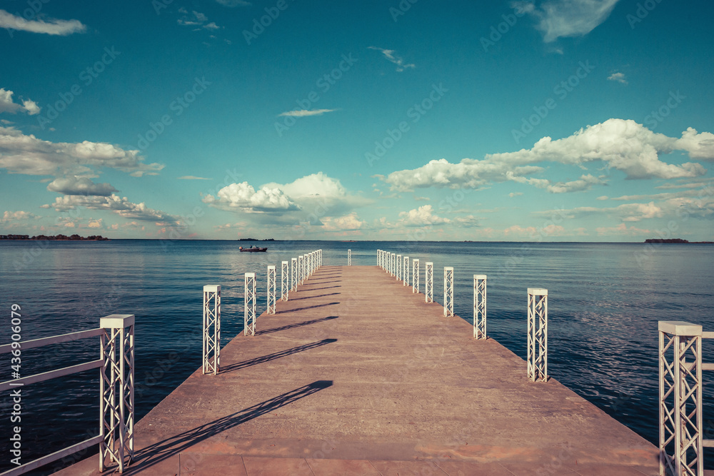 A boat dock on the river under a cloudy sky