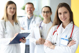 Medical doctors in white coats stand together