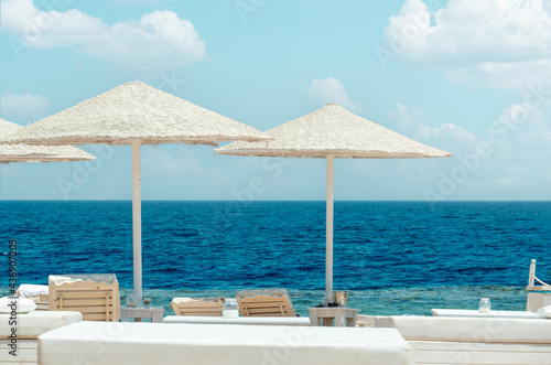 beach of the hotel resort, beach umbrellas and sun loungers against the backdrop of the beautiful sea. Empty beach sea summer background
