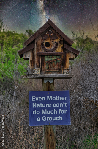 Wooden birdhouse with sign and Milky way on background photo