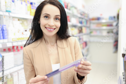 Portrait of smiling woman choosing toothbrush in store