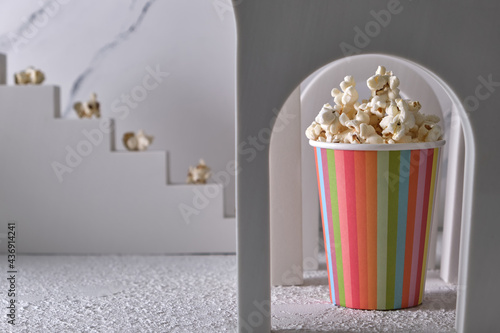 Striped paper cup with popcorn in a decorative arch