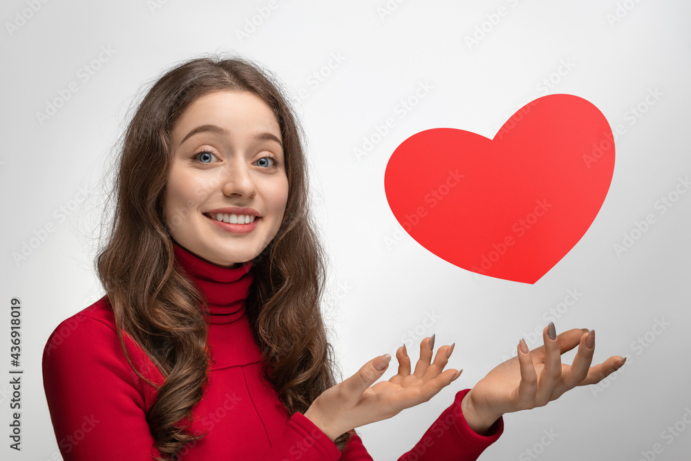 Girl with red cardboard heart, heart hanging in the air Girl with red cardboard heart, heart hanging in the air