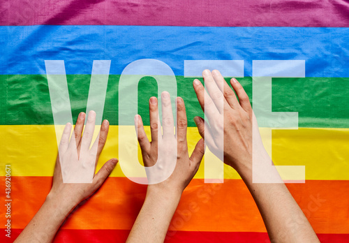 LGBT people voting. LGBT Elections. Hands of people on LGBT flag background photo