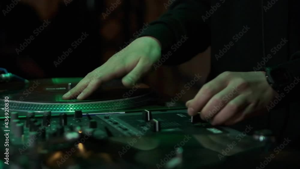 Hip hop dj scratching vinyl records on turntables in slow motion