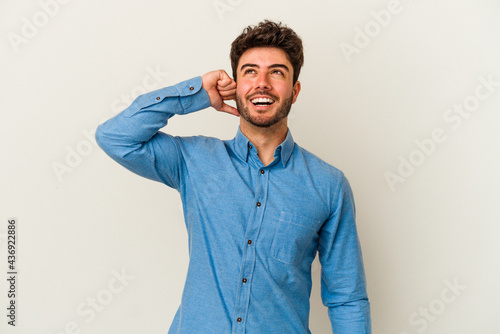 Young caucasian man isolated on white background celebrating a victory, passion and enthusiasm, happy expression. © Asier